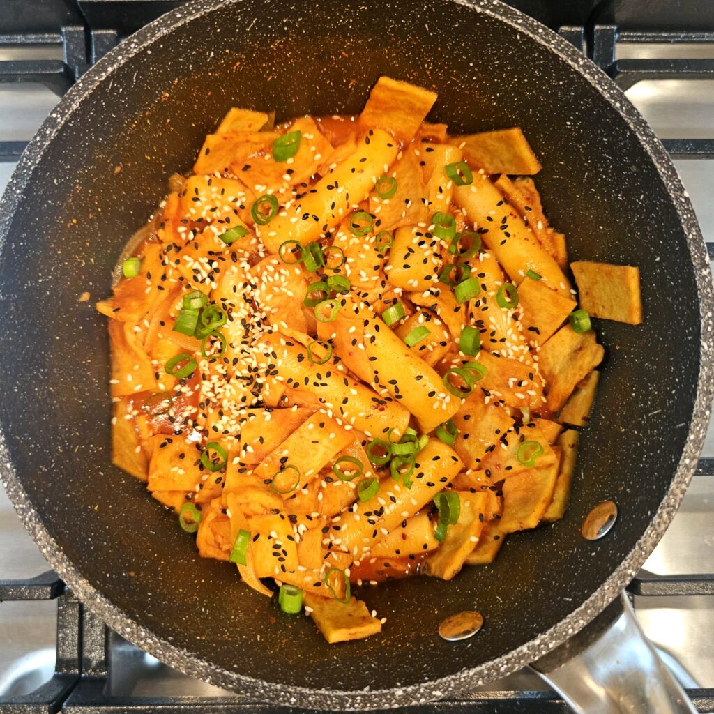 Rice cakes and fish cakes simmering while the spicy sauce thickens.