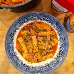 A blue and white patterned plate filled with spicy Korean rice cakes and fish cakes.